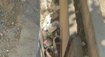 La acequia que está al lado de un hospital y está tapada de basura